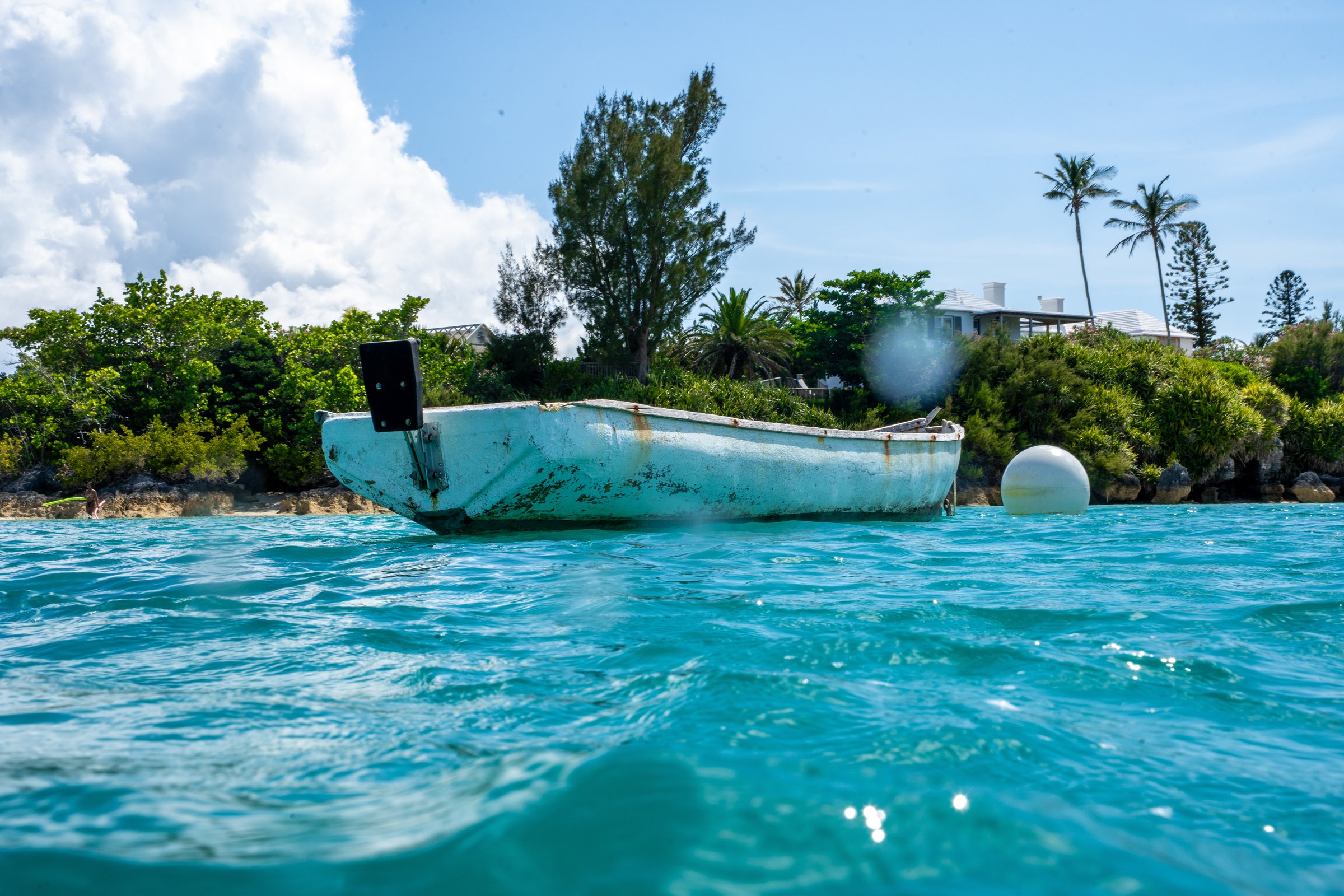 Abandoned boat at water level, tropical shore